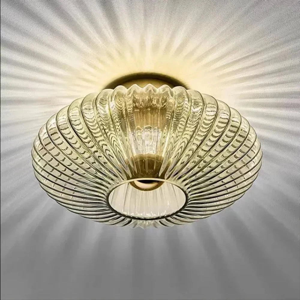 Decorative ceiling light fixture with a ribbed glass shade on a gray background