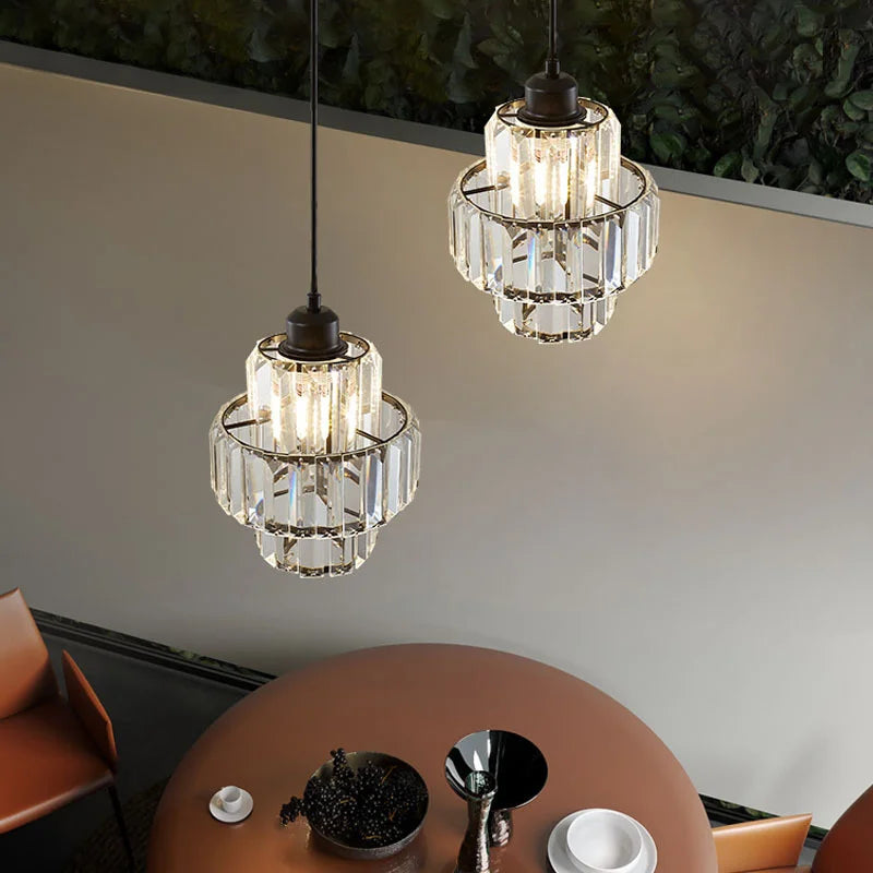 Two crystal pendant lights hanging above a table with decorative items.