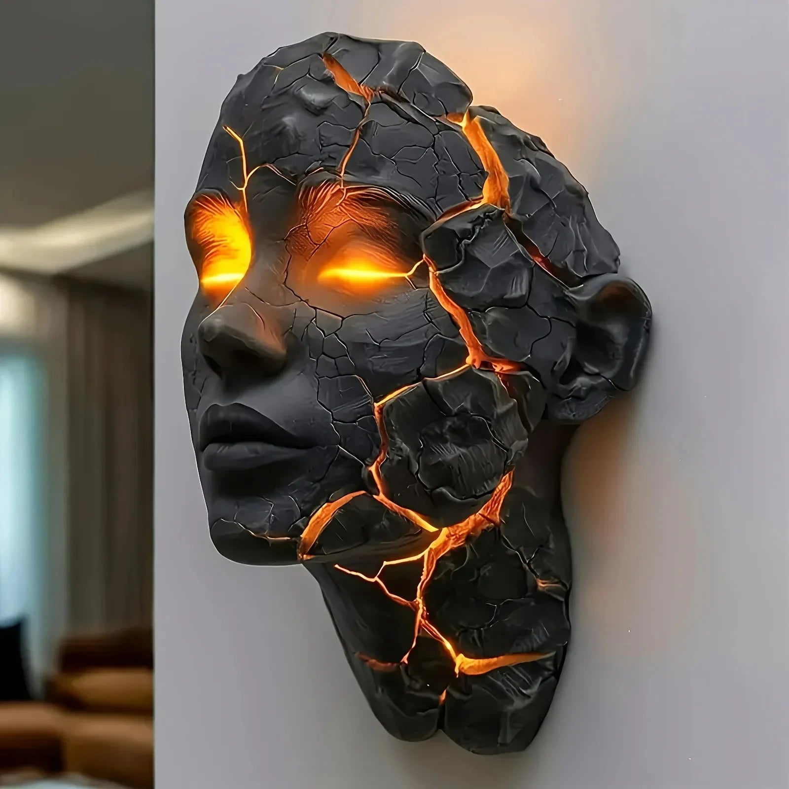 Decorative wall art of a face with glowing orange cracks on a plain background