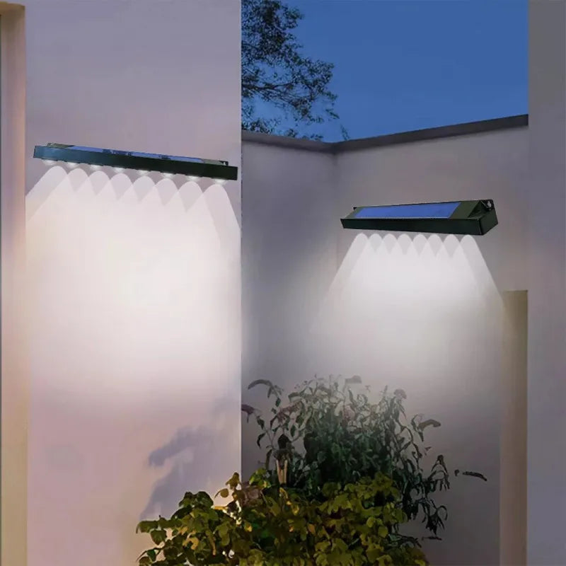 Solar wall lights on a building exterior with plants and sky in the background