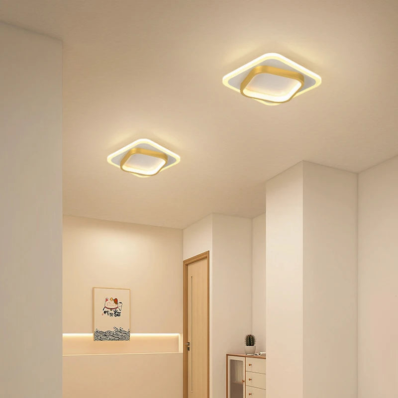 Two square ceiling lights in a room with neutral walls and a door.