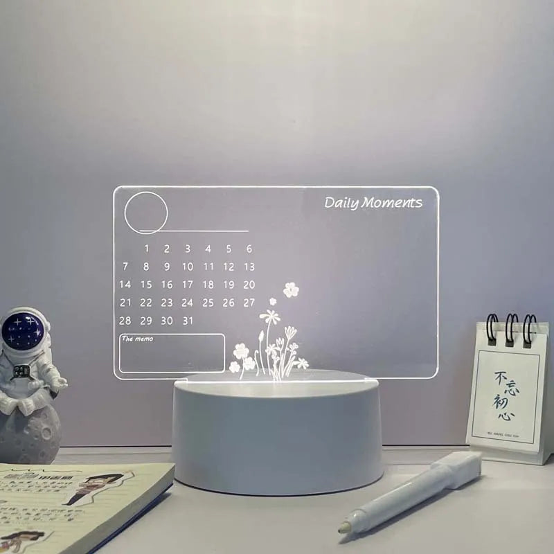 Tabletop device with digital calendar and floral display on a desk.