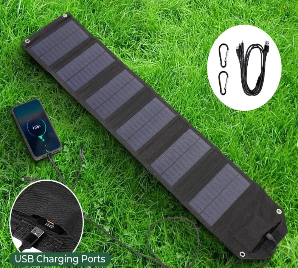 Folding solar panel on grass with USB charging ports and dimensions displayed