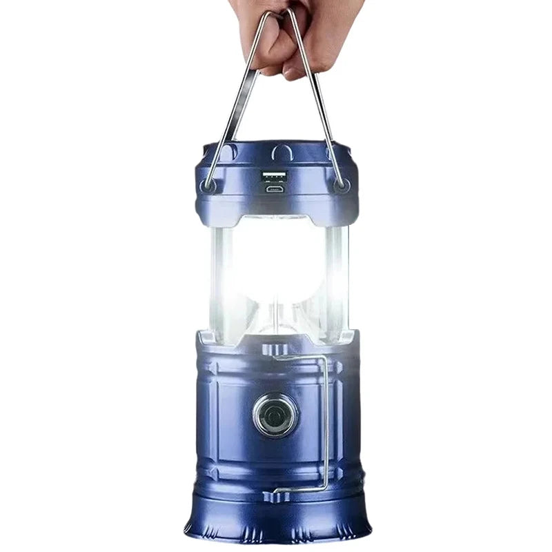 Blue camping lantern held by a hand on a white background