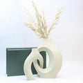 White abstract vase with dried plants on a white background