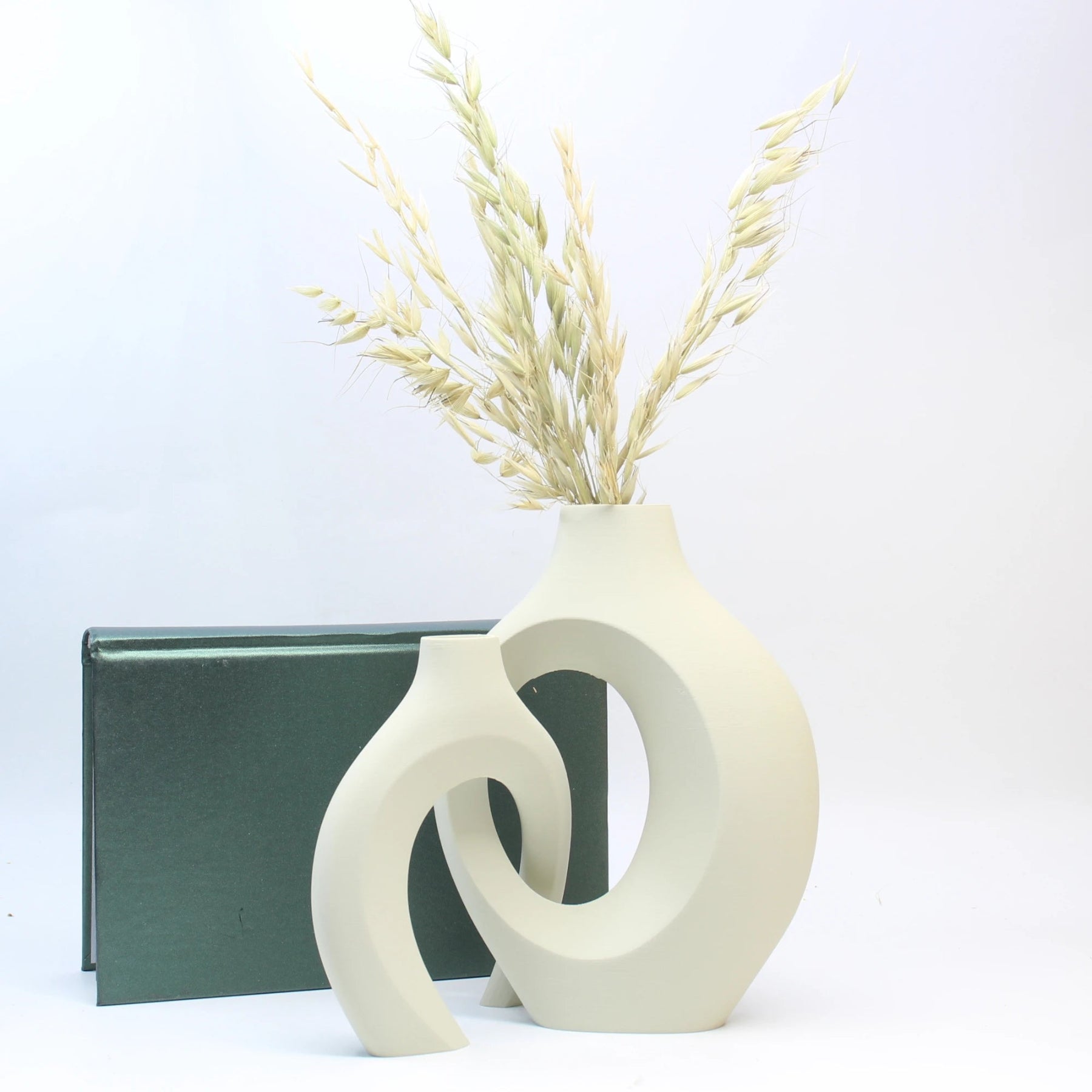 White abstract vase with dried plants on a white background