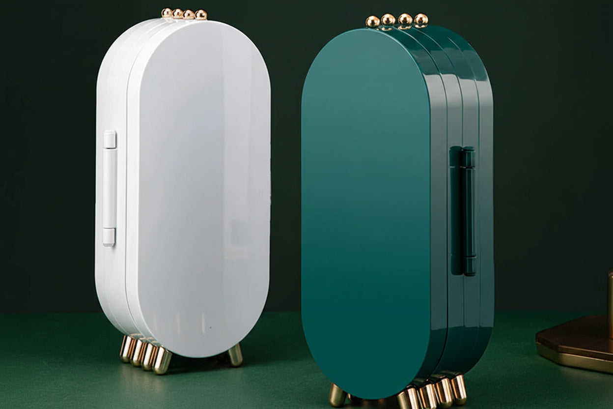 Two travel cases, one white and one teal, on a green surface with a dark background.