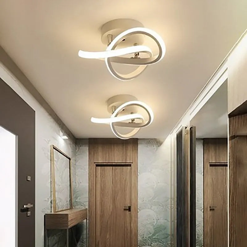 Modern ceiling lights in a hallway with wooden doors and a mirror.