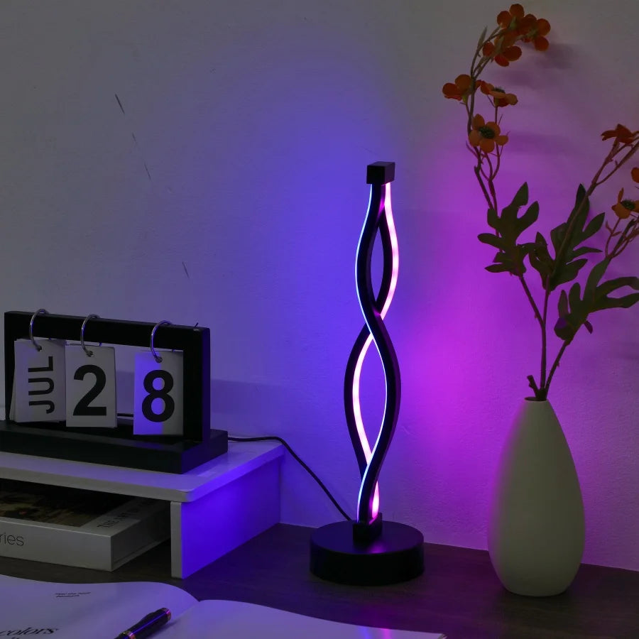 Modern LED lamp with purple light on a desk next to a calendar and vase