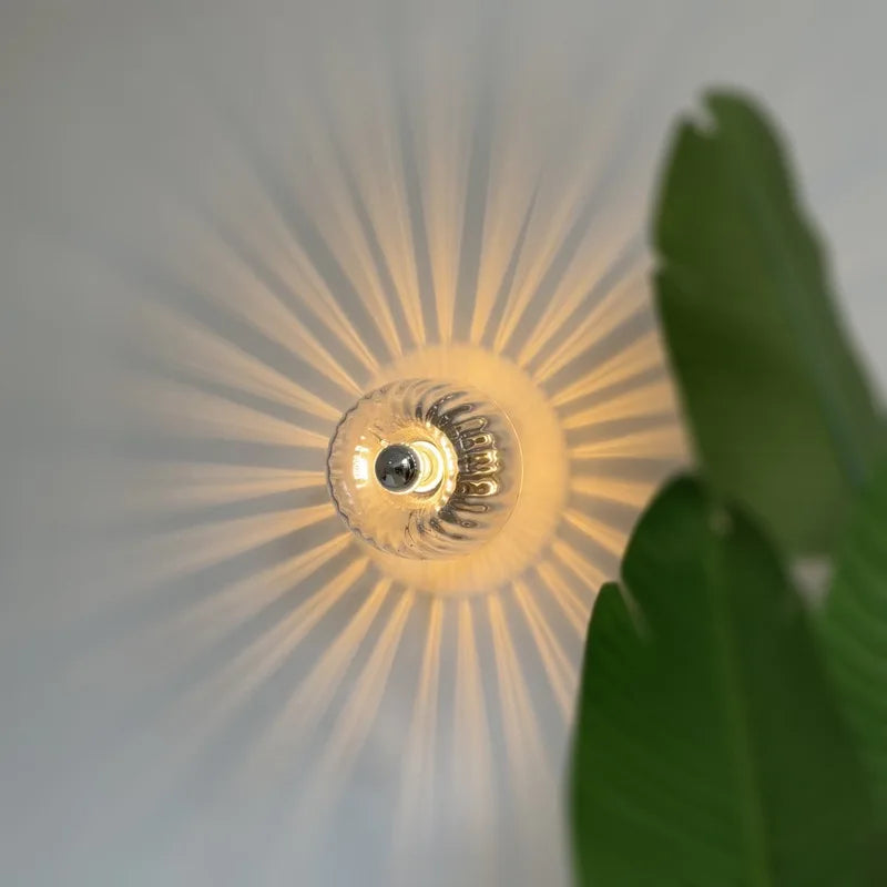 Decorative light fixture with sunburst pattern on a neutral background