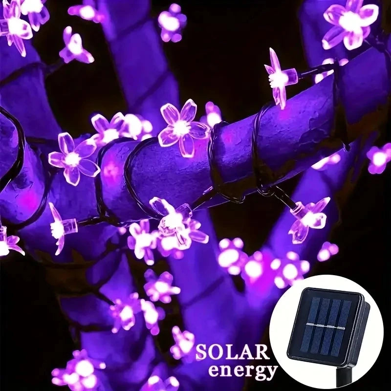 String of purple flower-shaped lights with solar panel indicator on a dark background