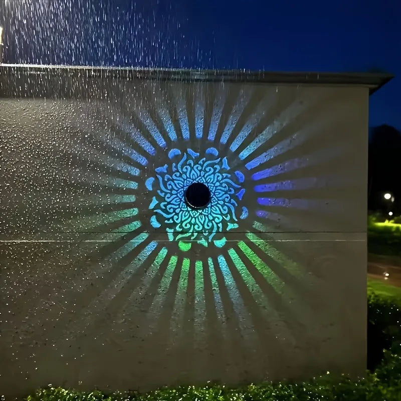 Colorful circular design projected onto a wall at night