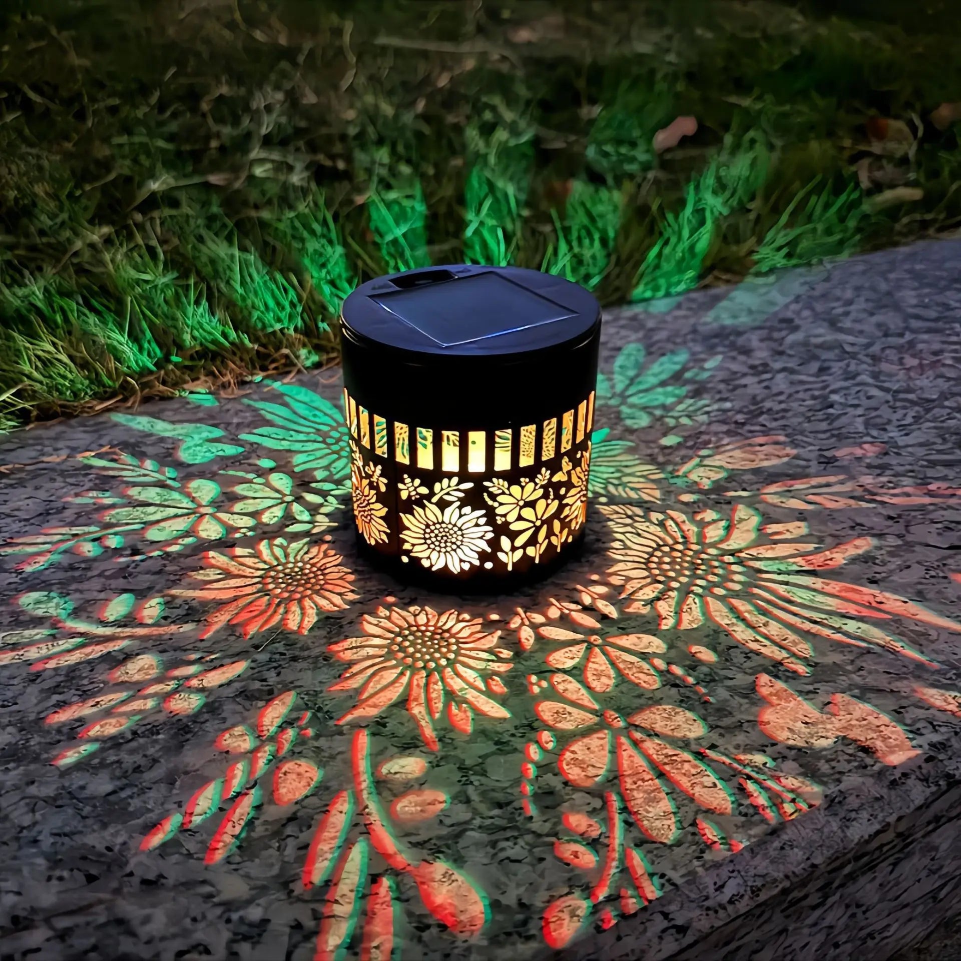 Solar-powered lantern with floral design casting patterns on a stone surface
