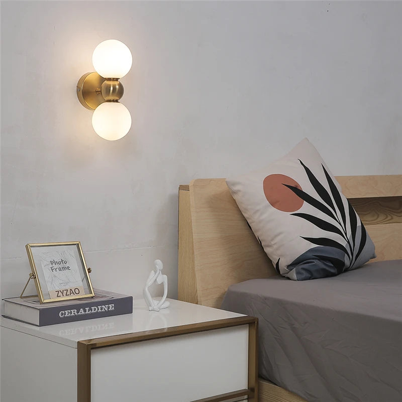 Modern bedroom with wall sconces, a bed, and decorative items.