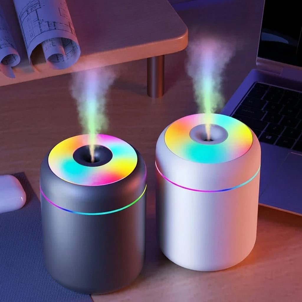 Two colorful humidifiers on a desk with a laptop and mouse in the background.