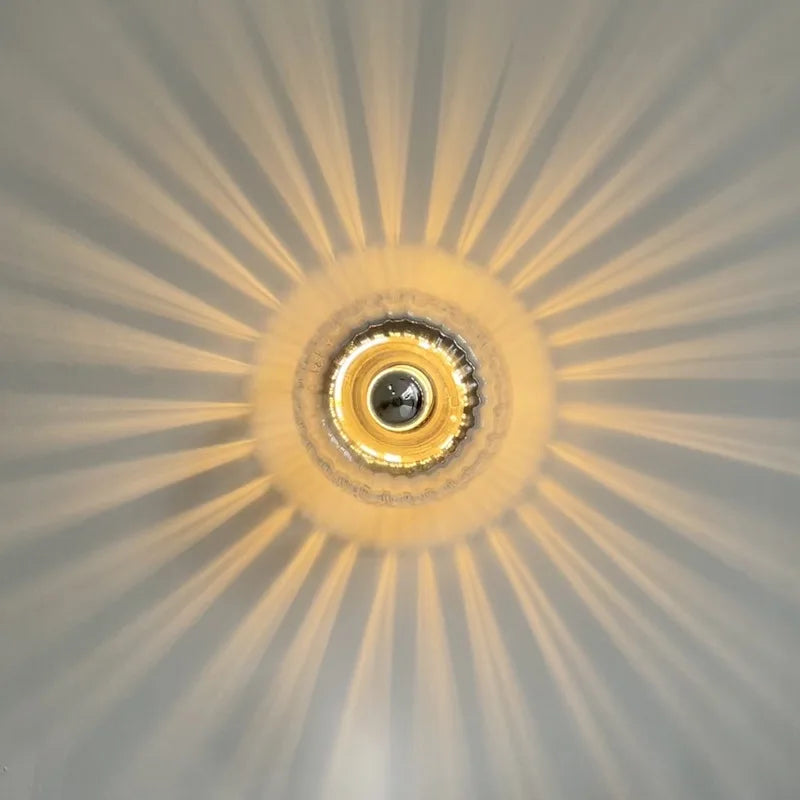 Close-up of a ceiling light fixture with a sunburst pattern