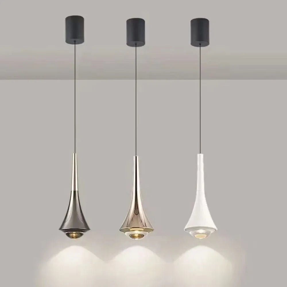 Three modern pendant lights hanging against a neutral background