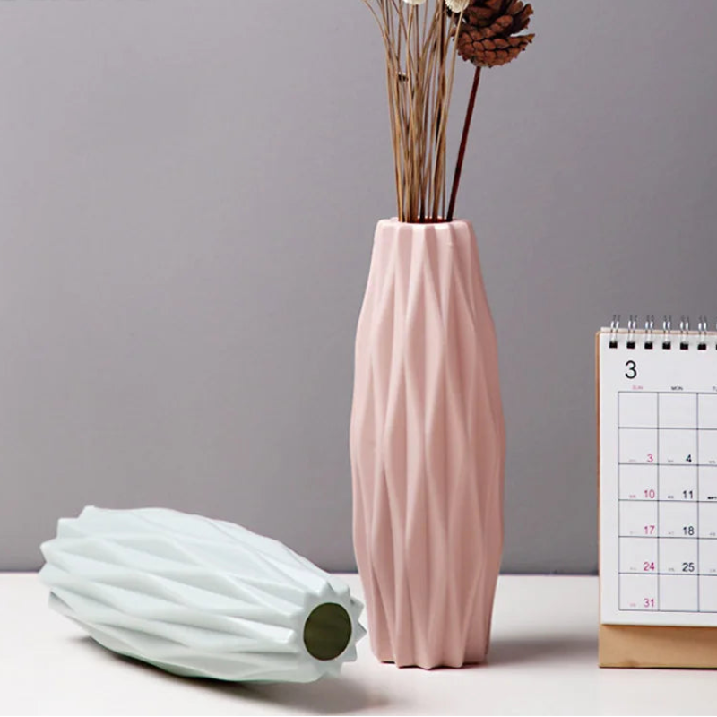 Pink textured vase with dried flowers on a gray background, featuring the brand 'Gekiwt'.