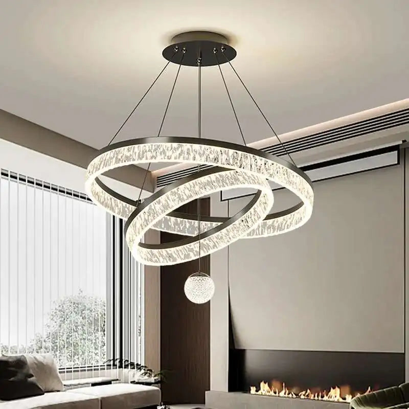 Modern chandelier hanging in a living room with a fireplace.