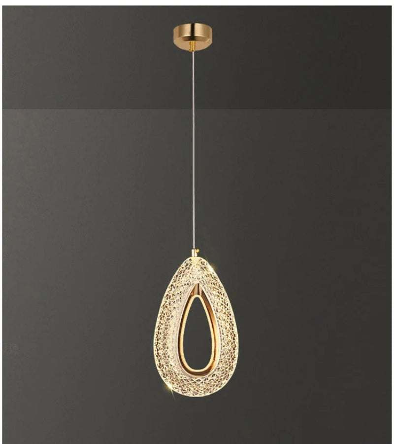 Gold pendant light fixture against a black background