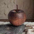 Rust-colored apple on a stone surface with a blurred background