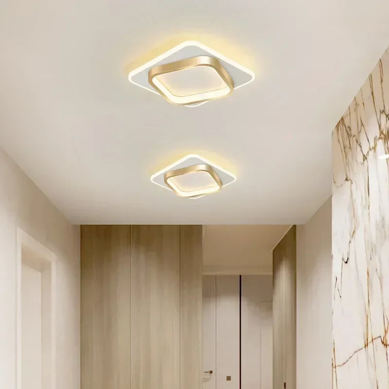 Two square ceiling lights on a white ceiling in a room with marble walls.