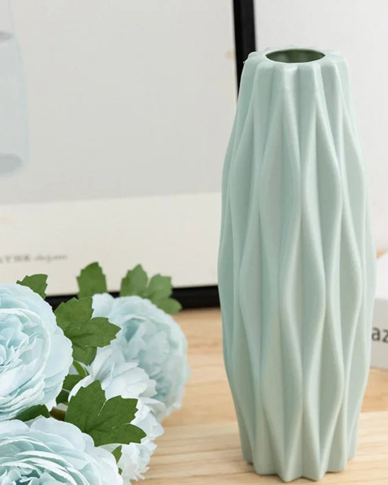 Light green textured vase on a wooden surface with floral decorations and measurement text.