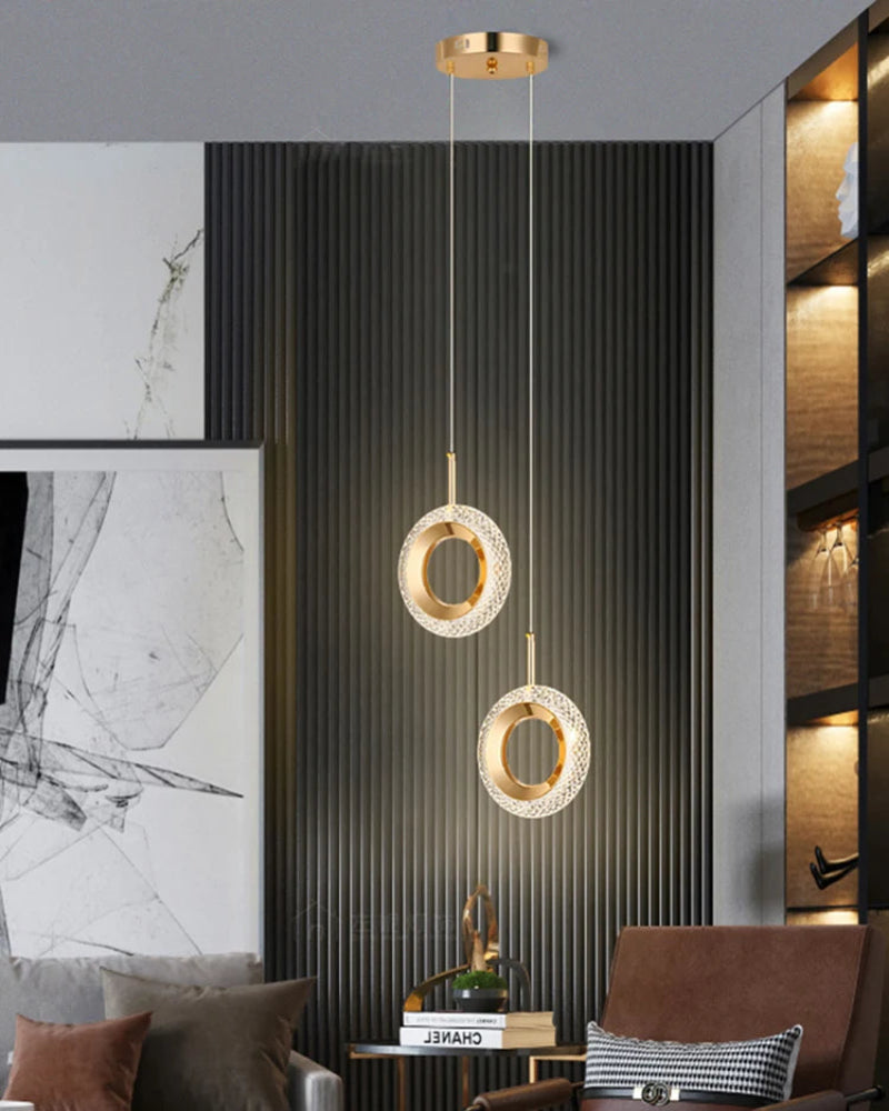 Modern pendant light fixture in a stylish interior setting with a sofa and artwork.