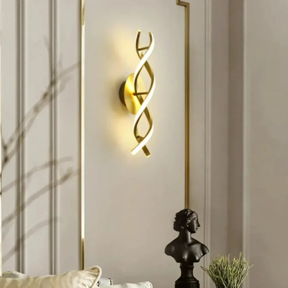Decorative wall sconce with a gold spiral design on a neutral wall.
