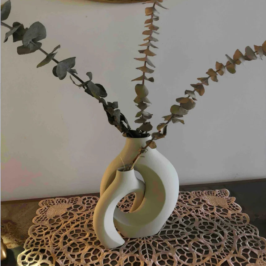 Decorative vase with eucalyptus branches on a lace tablecloth