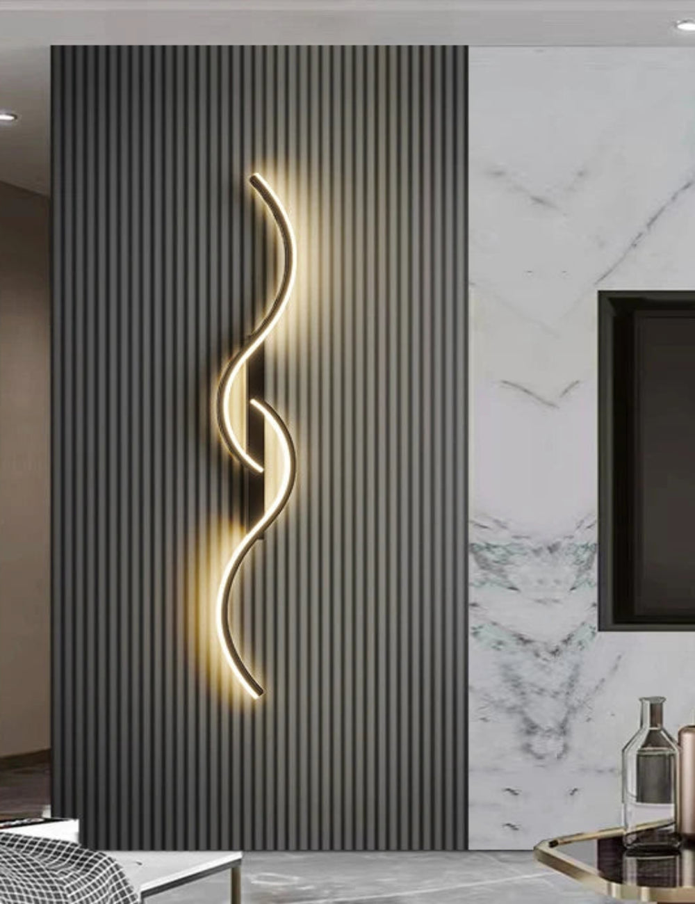 Modern interior design with a wall-mounted light fixture, marble wall, and decorative items.