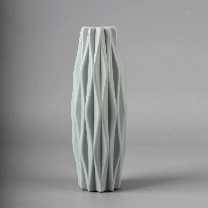 Green ceramic vase with textured surface on a gray background