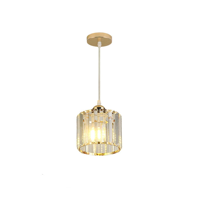 A single hanging pendant light fixture with a gold-toned ceiling canopy and rod, a cylindrical clear crystal or glass shade, and warm illuminated bulbs visible inside. 
