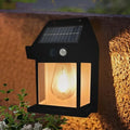 Solar-powered outdoor light fixture on a wall with a warm glow