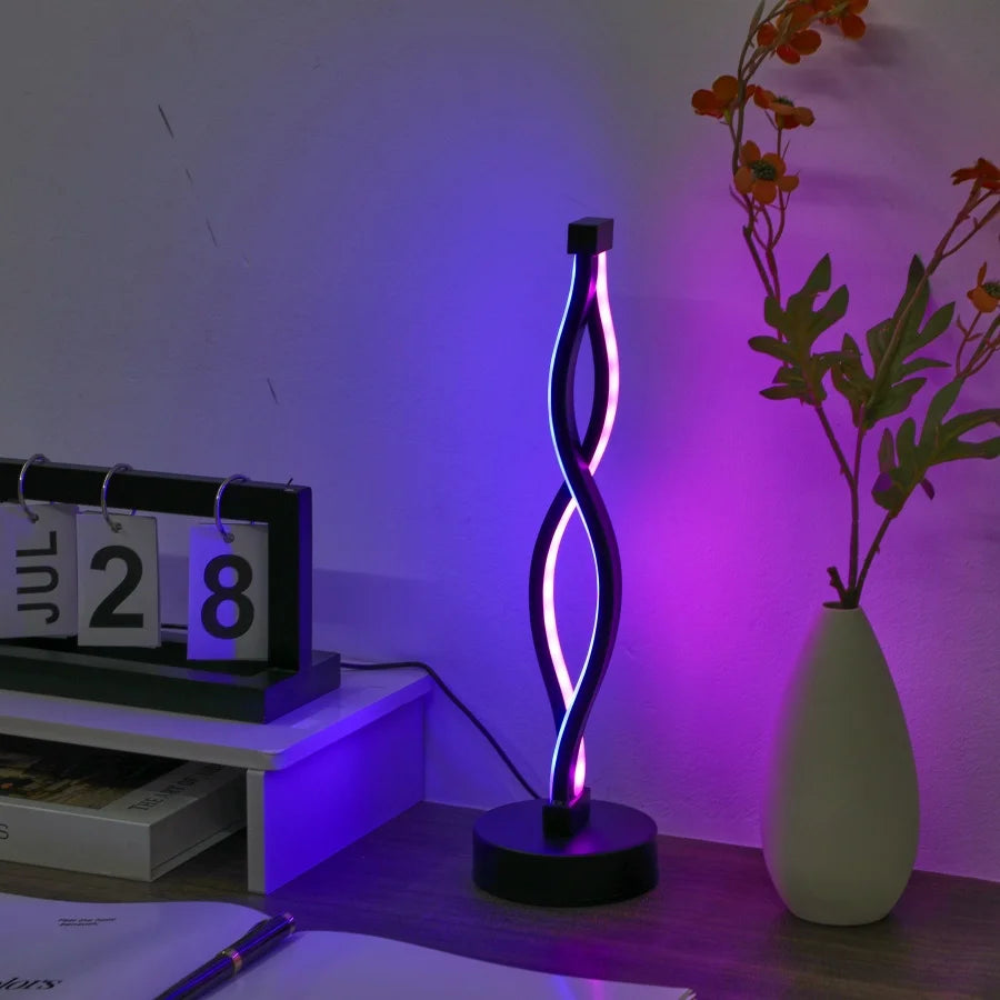 Modern LED lamp with wavy design on a desk next to a calendar and vase.