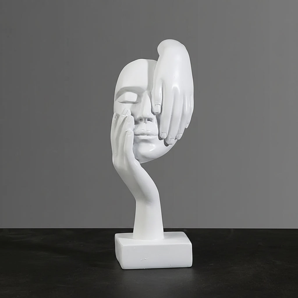 White abstract sculpture of a face and hand with dimensions indicated on a dark surface and gray background.