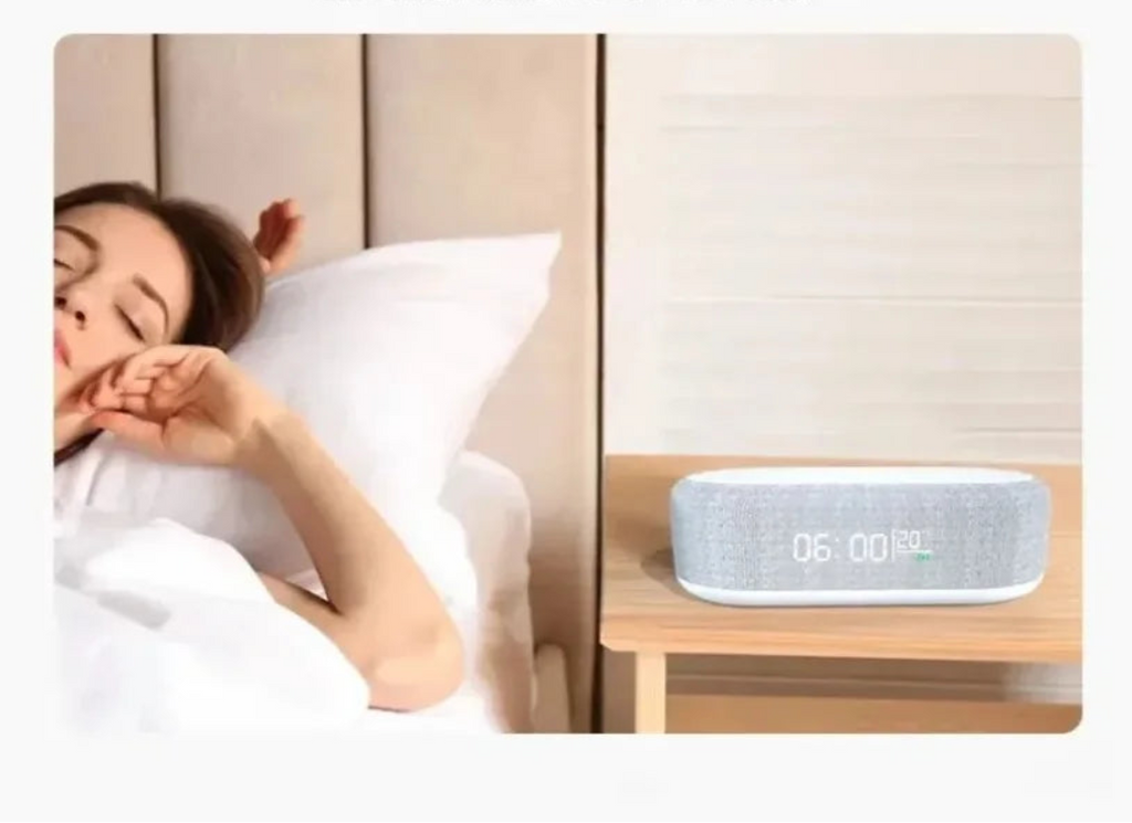 Woman sleeping in bed with a modern alarm clock on a nightstand.
