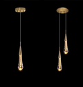 Two modern pendant lights with gold fixtures on a black background