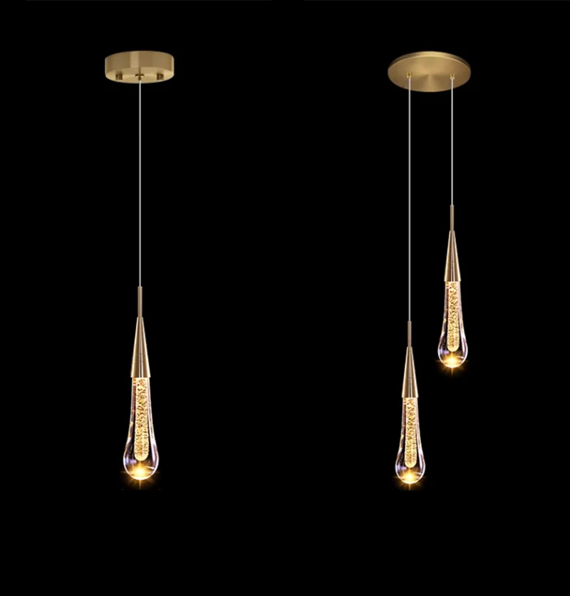 Two modern pendant lights with gold fixtures on a black background