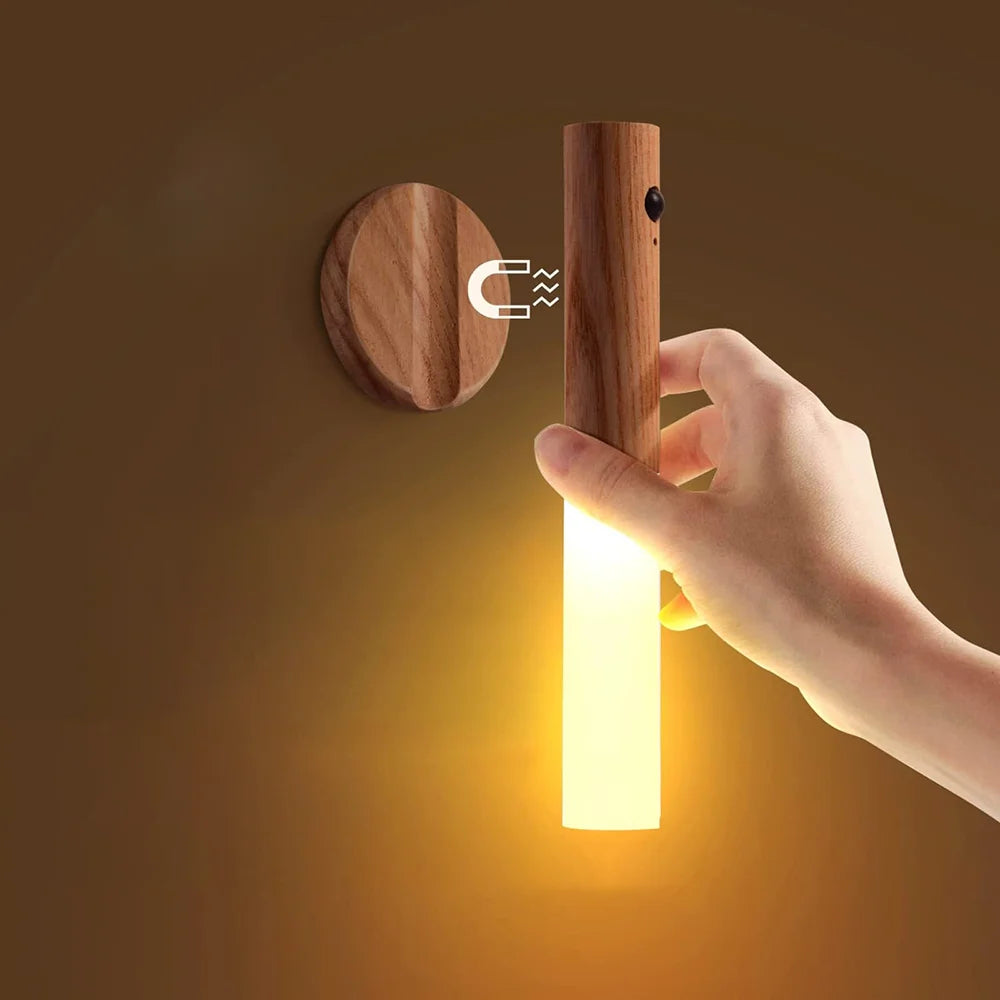 Wooden wall light fixture with a hand turning it on against a brown background