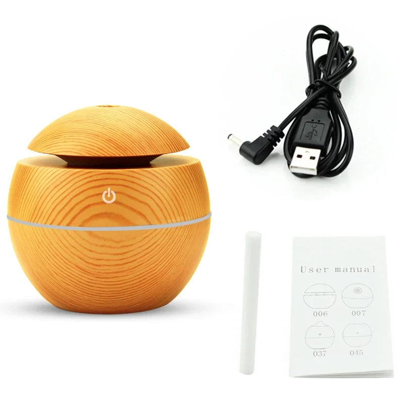 Orange diffuser with power cable, user manual, and cleaning stick on a white background