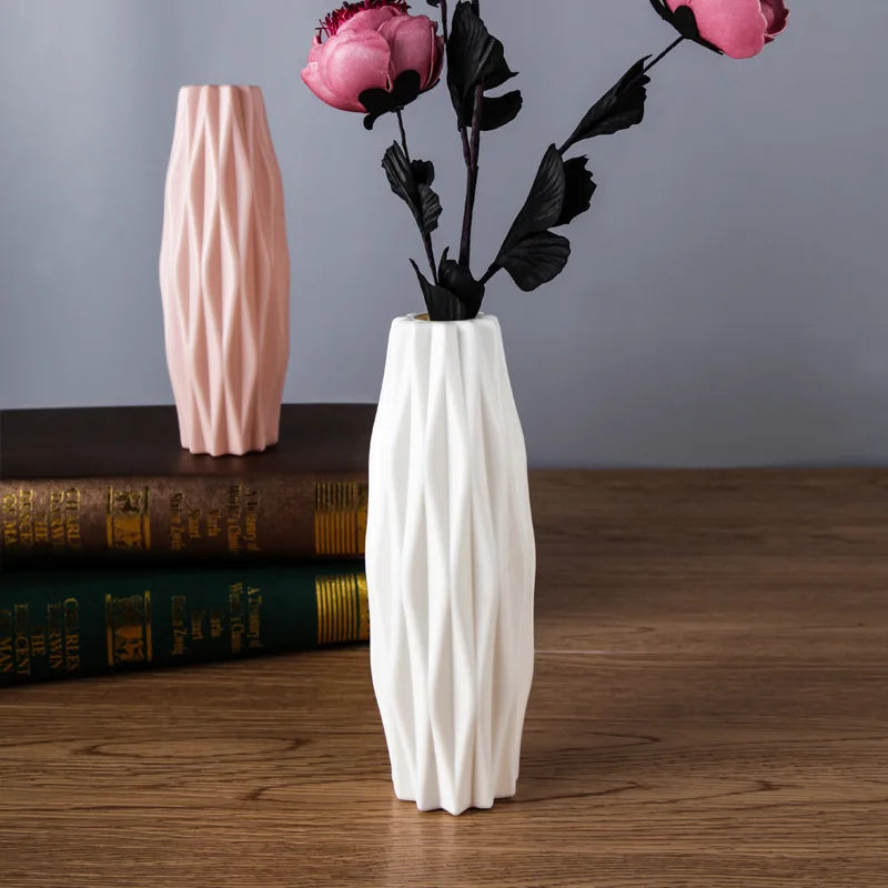 White textured vase with pink flowers on a wooden surface