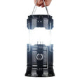 Black camping lantern held by a hand on a white background
