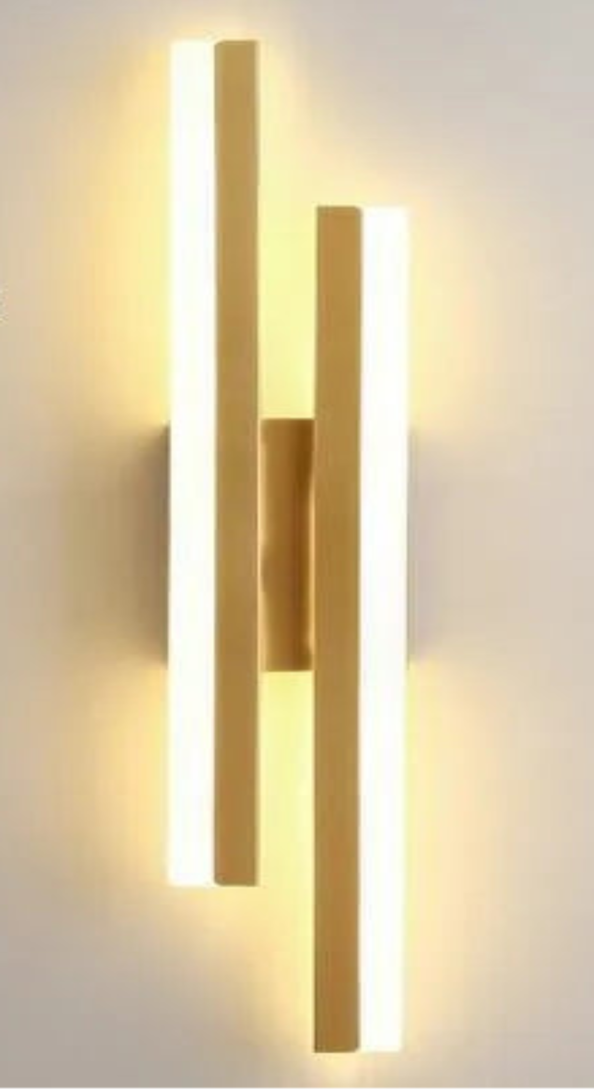 Gold wall-mounted light fixture on a white wall with text detailing dimensions and features.