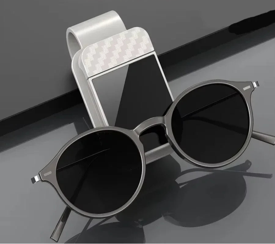 Sunglasses with a car mount on a reflective surface, featuring text about product features.