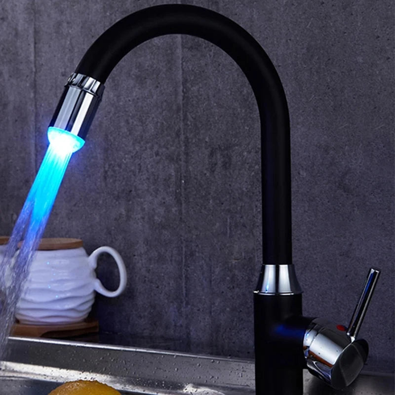 Black faucet with LED light emitting blue water stream on a dark background