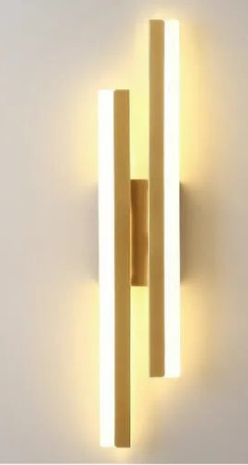 Gold wall-mounted light fixture with LED indicators on a plain background