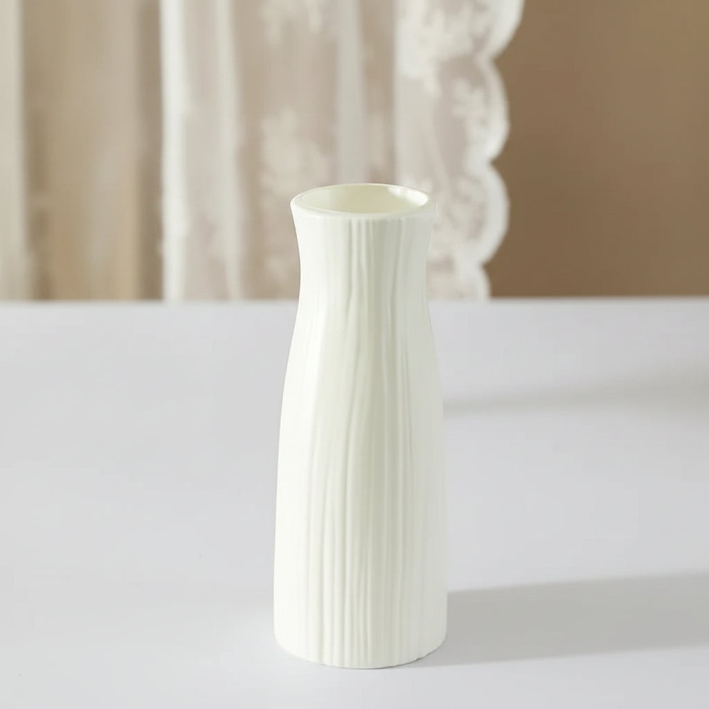 White vase with measurements on a surface with a hat and radio in the background