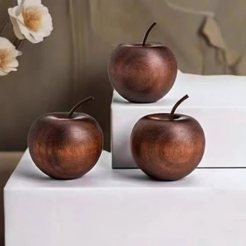 Three decorative apples with measurements on a white surface