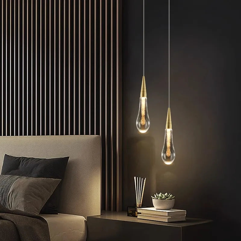 Modern bedroom with hanging pendant lights, a bed, and decorative items.